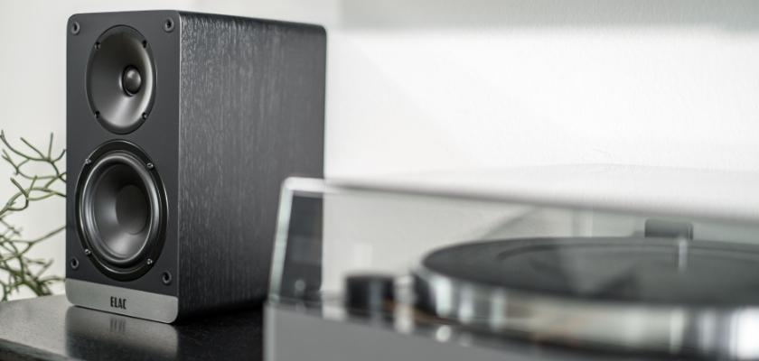 Der ELAC ConneX DCB41 in Schwarz neben einem Plattenspieler